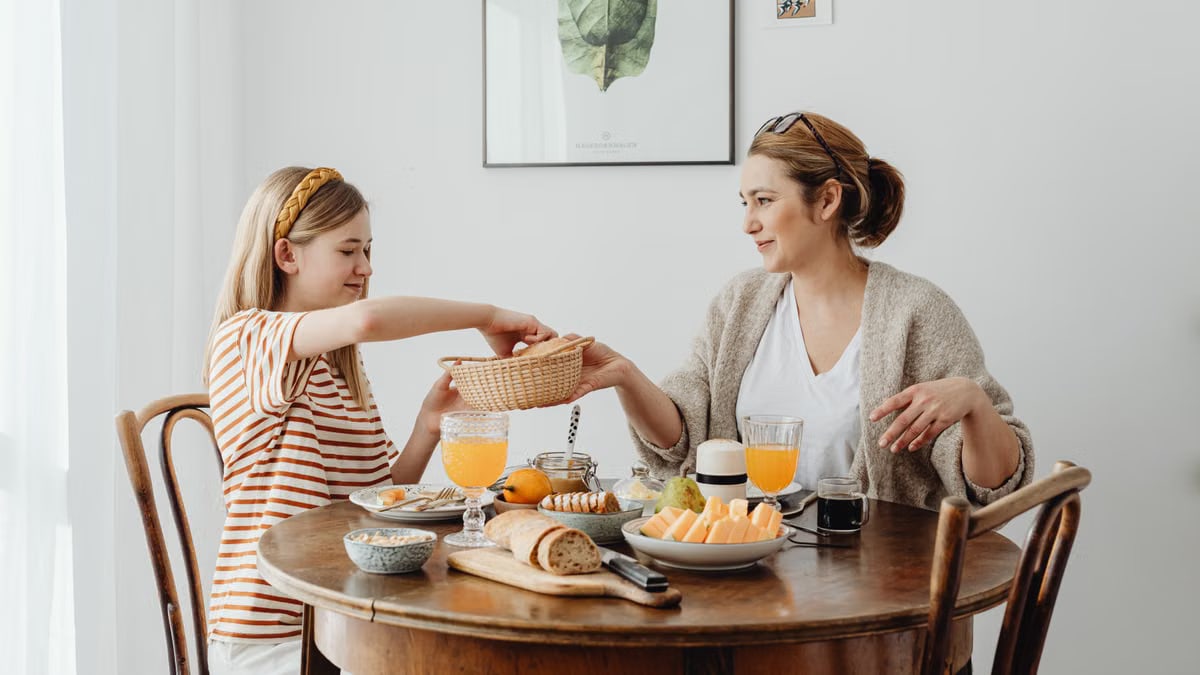 A warm family breakfast with mother and daughter sharing a meal in a cozy dining area.